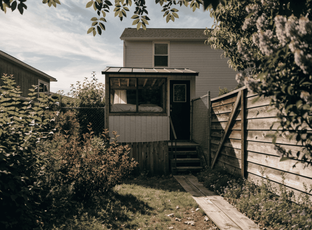 Backyard ADU - Small Homes USA Newsletter Small backyard with a tiny house and wooden fence, cozy outdoor space.