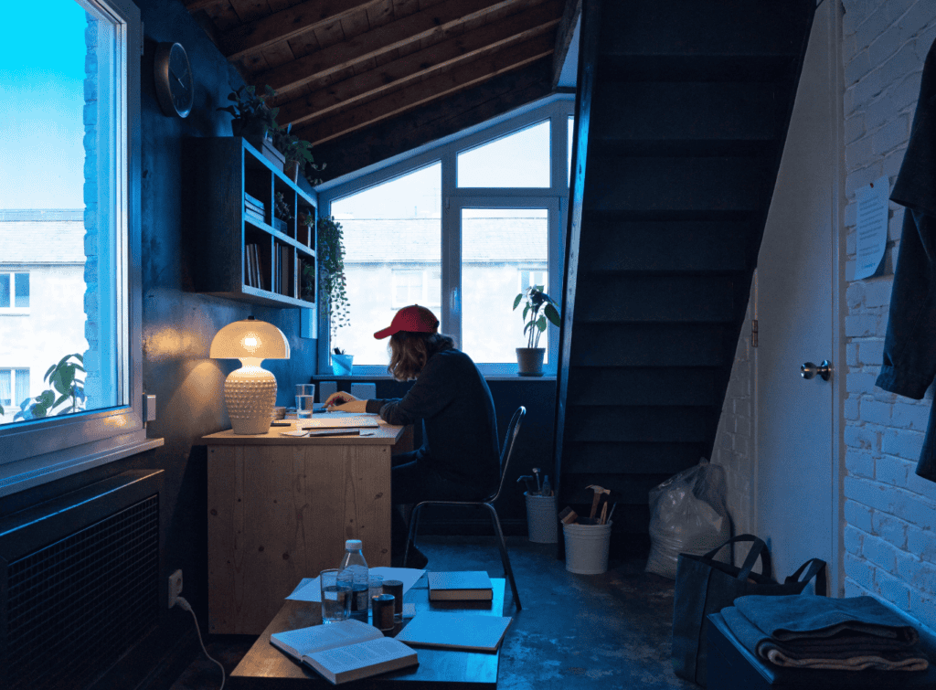 Micro Apartment Design - Small Homes USA Newsletter Cozy home office with a person working at a desk near a window.