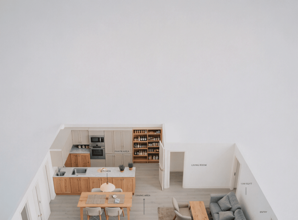 Small farmhouse floor plan with walk-in pantry layout - Small Homes USA Newsletter Top-down 3D rendering of an open-concept home: kitchen with island, dining area, pantry shelves, and living room beyond