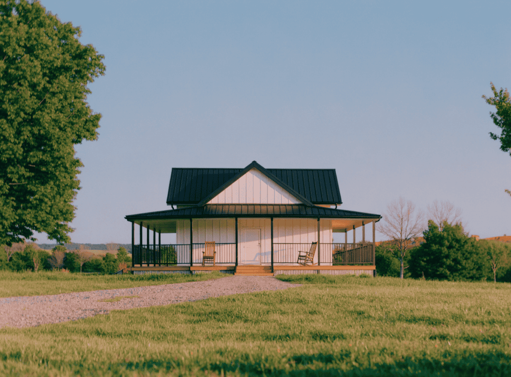 White Barndominium - Small Homes USA Newsletter Charming small house with porch and metal roof in rural setting.