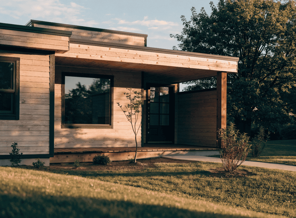 Wood Siding - Small Homes USA Newsletter Modern small home with wooden exterior and large windows in natural setting.